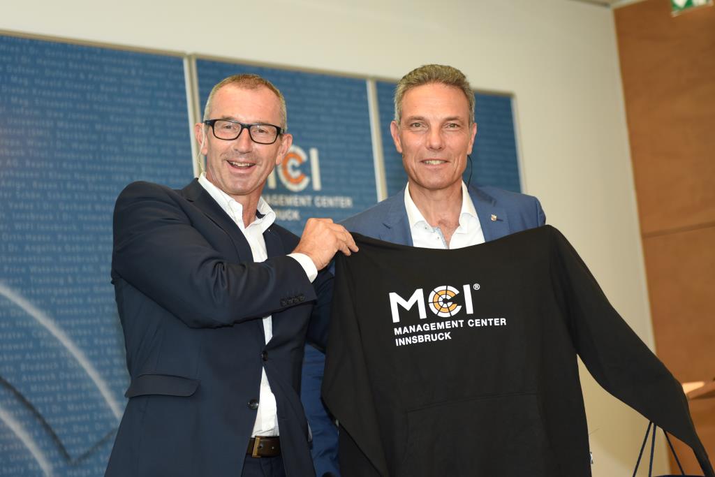 Andreas Altmann überreich Michael Krammer einen MCI Pullover.