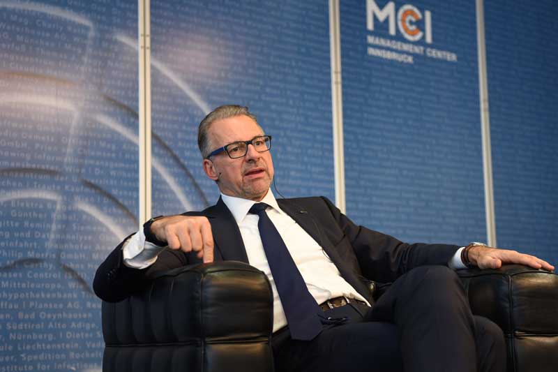 Dr. Josef Aschbacher sitting on a black chair