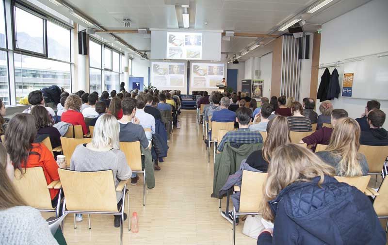 Der gefüllte Hörsaal von hinten fotografiert.