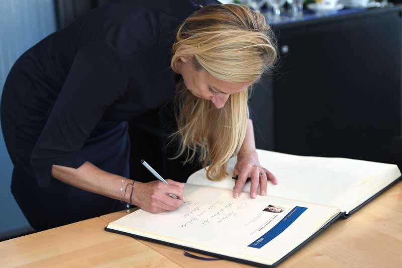 Dr. Juliane Bogner-Strauß signs a sheet of paper