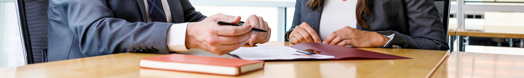 Two people sitting together at a table with different documents