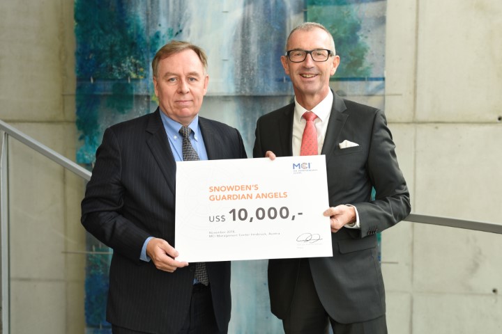 MCI-Rektor Andreas Altmann (rechts) übergibt einen Spendenscheck über 10.000 USD an Snowden-Anwalt Robert Tibbo (links). Foto: MCI