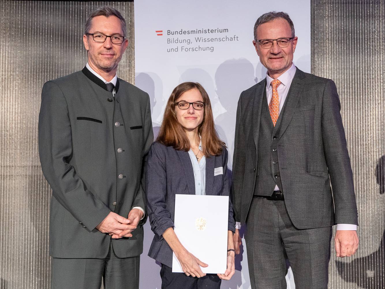 MCI-Preisträgerin Mag. Sarah Wetzel mit Sektionschef Mag. Elmar Pichl (links) und ihrem Betreuer Dr. Armin Fidler (rechts). Foto: BMBWF/Martin Lusser