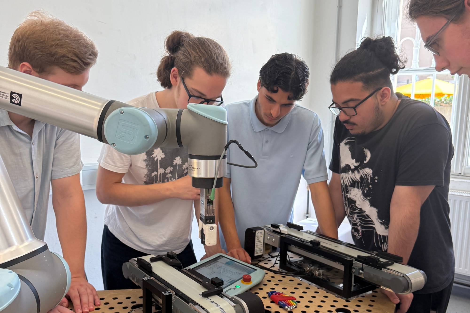 <p>Schüler fokussieren sich auf die Anwendung von Industrierobotern in modernen Produktionsanlagen</p>