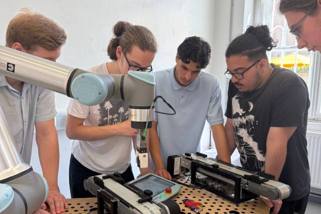 <p>Schüler fokussieren sich auf die Anwendung von Industrierobotern in modernen Produktionsanlagen</p>