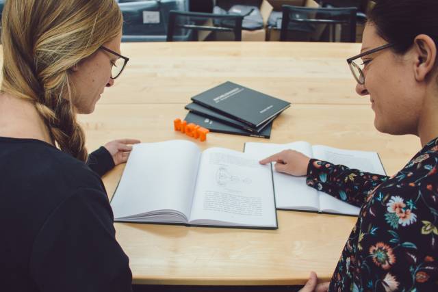 <p>Lektorin Teresa Spieß und Assistentin Elisabeth Rabanser schmökern in MCiT Bachelorarbeiten <span style=
